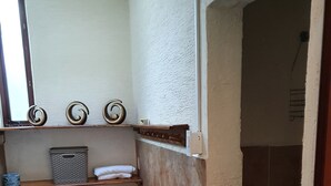 Een kleine badkamer met toilet, wastafel en douche.