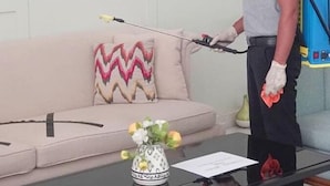 A person cleaning a living room with a spray bottle and a long wand. - d'primahotel Balikpapan (Balikpapan)