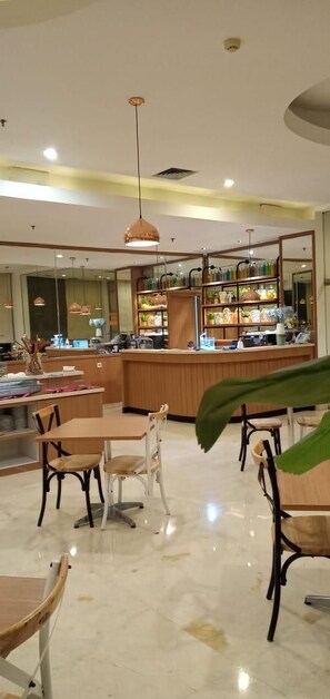 A restaurant with a bar area, wooden furniture, and a large mirror.