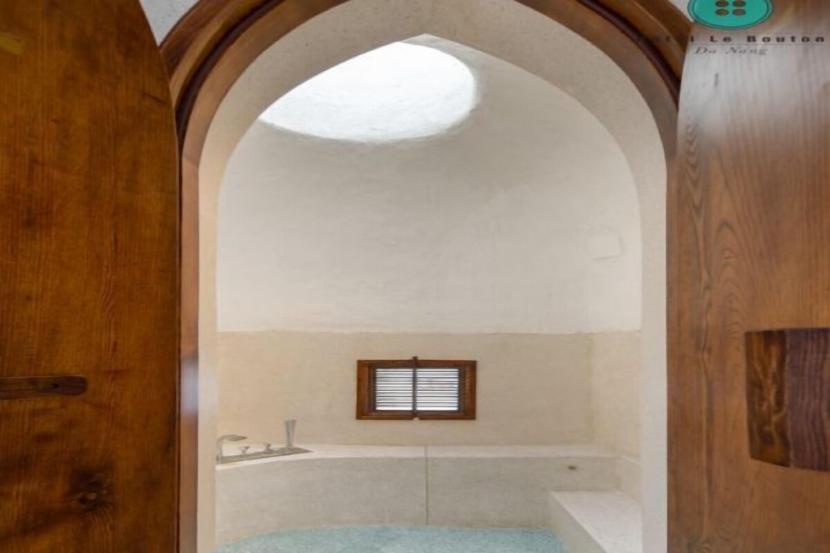 A bathroom with a skylight, a window, and a bathtub.