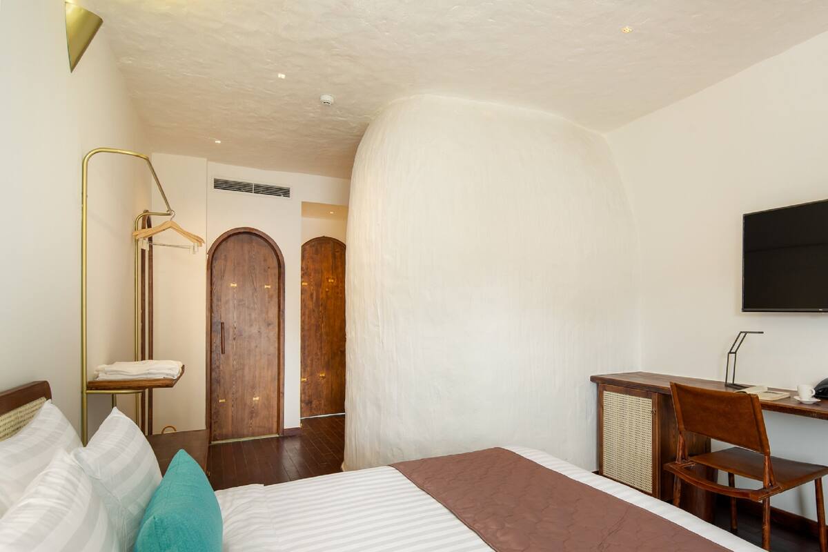 Une chambre d’hôtel avec un grand lit, un bureau et une télévision.