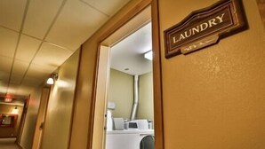 Un couloir d’hôtel avec un panneau indiquant l’emplacement de la laverie.