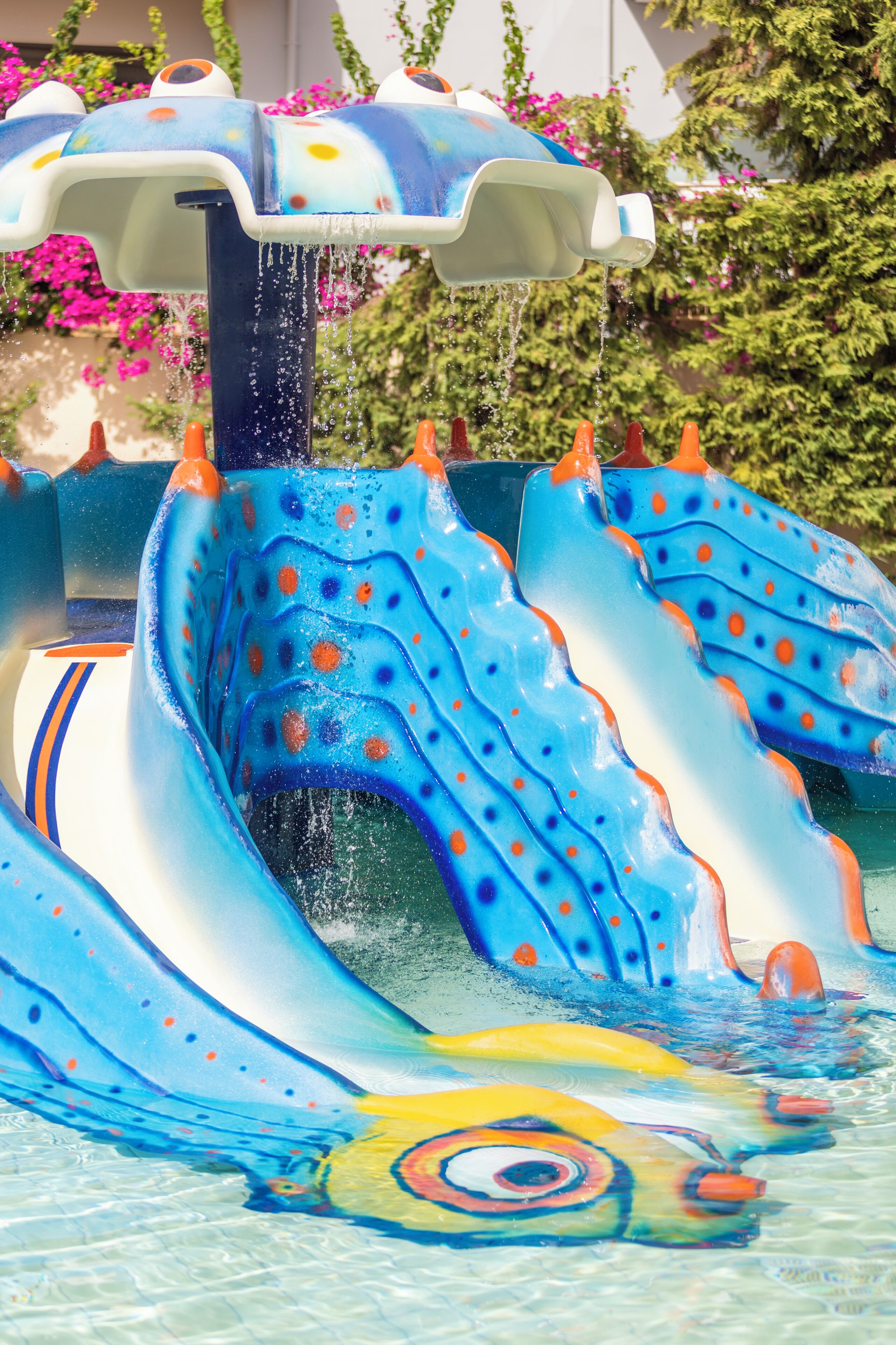 A water feature with a blue and white design, including a wave-like structure and a yellow circular element at the bottom.
