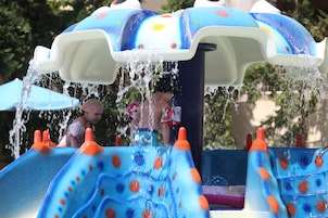 Una piscina al aire libre, sombrillas, sillones reclinables de piscina