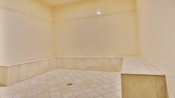 A room with a tiled floor and walls, a corner sink, and a ceiling light fixture. - 1 BDRM / King / AC / Hot Tub & Pool (Fernie)