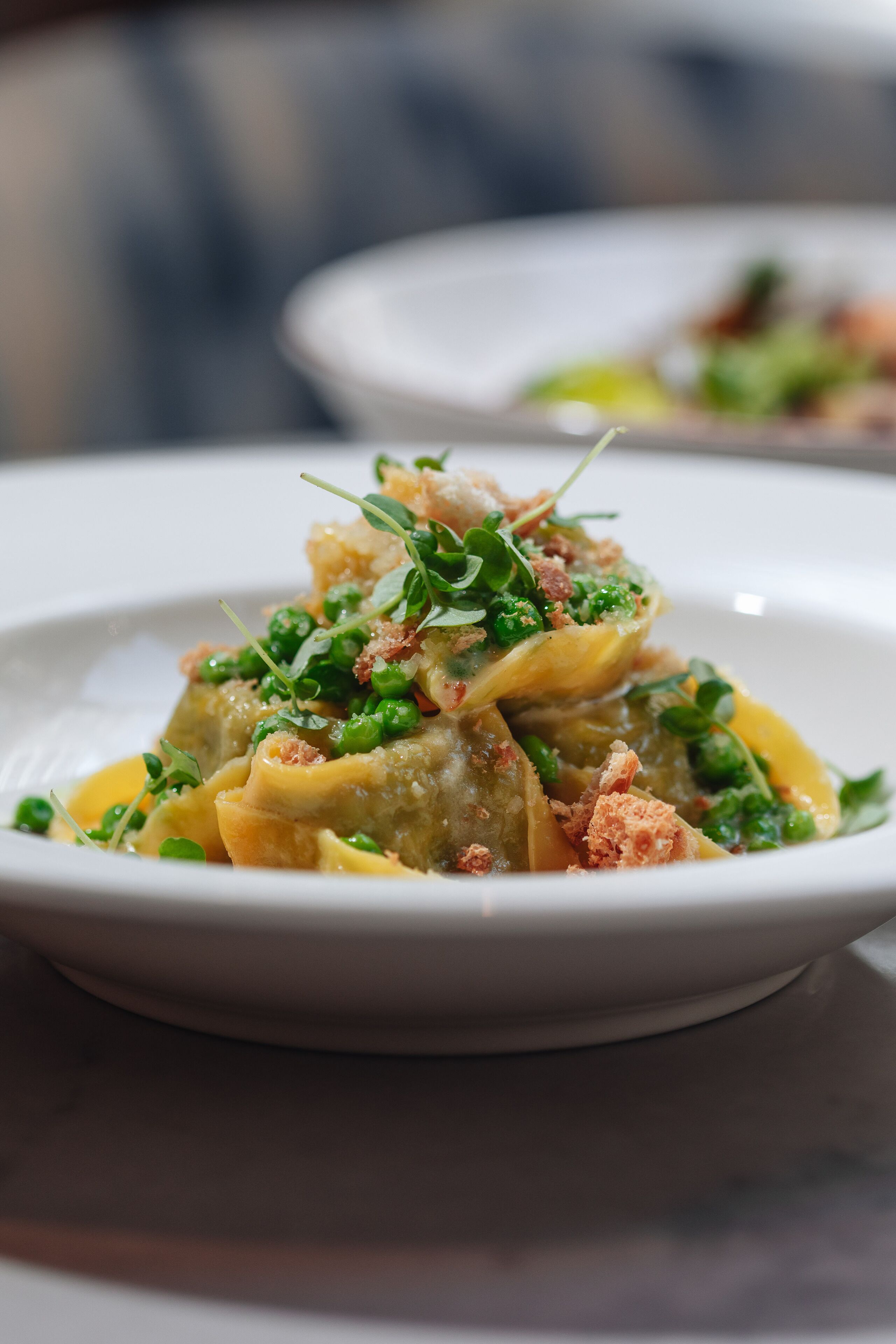 A plate of pasta with greens and croutons.
