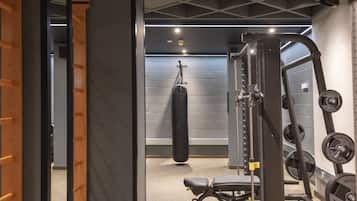Ein Fitnessraum mit einem Sandsack, Gewichten und einer Bank.