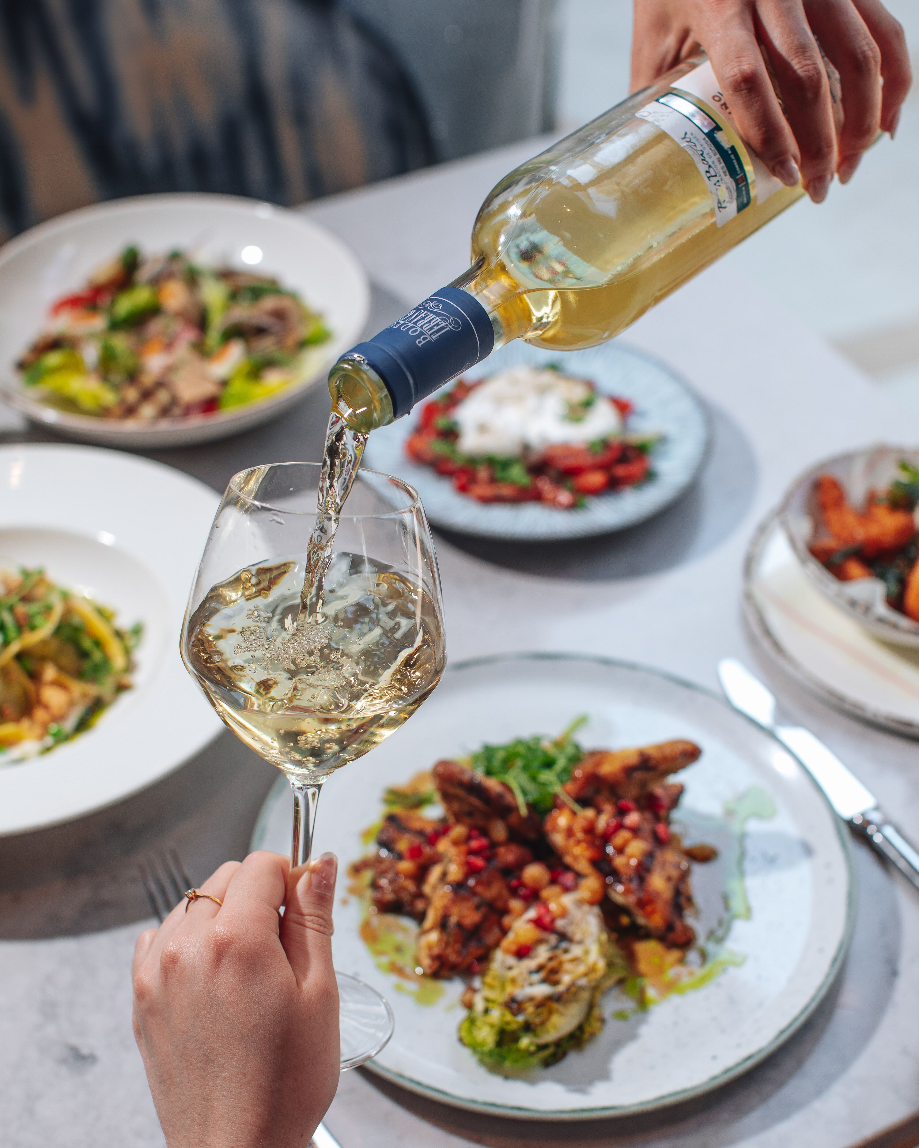 A person pouring wine into a glass.