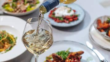 A person pouring wine into a glass.