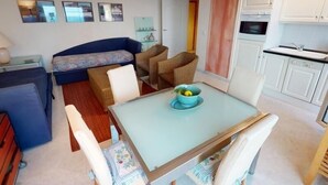 A compact living space with a dining table, a sofa, and a kitchen area. - Spacious 1-Bedroom Apartment with Sea View, Balcony, Pool, and Parking in Central Menton (Menton)