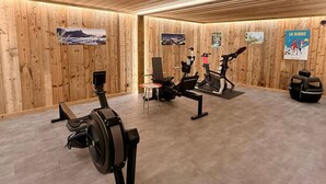 A gym with wooden walls, exercise equipment, and posters. - Stunning Chalet for 13 - Spacious Living Area, 4 Bedrooms, Garage, WIFI - La Clusaz (La Clusaz)