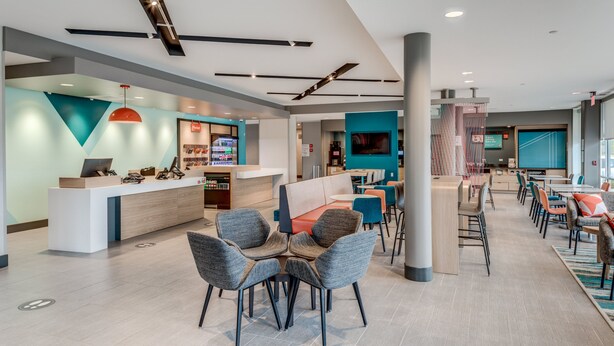 A modern hotel lobby with a reception desk, seating area, and dining space. - avid hotel Zeeland - Holland by IHG (Zeeland)