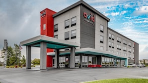 A modern hotel with a prominent 'avid' sign, a covered entrance, and a parking lot. - avid hotel Zeeland - Holland by IHG (Zeeland)