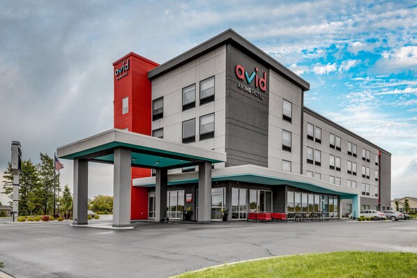 A modern hotel with a prominent 'avid' sign, a covered entrance, and a parking lot. - avid hotel Zeeland - Holland by IHG (Zeeland)
