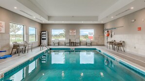 A swimming pool with clear blue water, surrounded by lounge chairs and a lifeguard on duty sign. - avid hotel Zeeland - Holland by IHG (Zeeland)