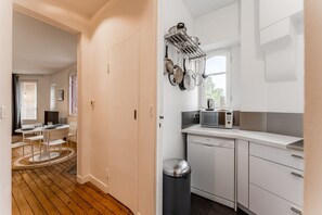 A modern kitchen with white cabinets, a Bosch dishwasher, and a microwave.