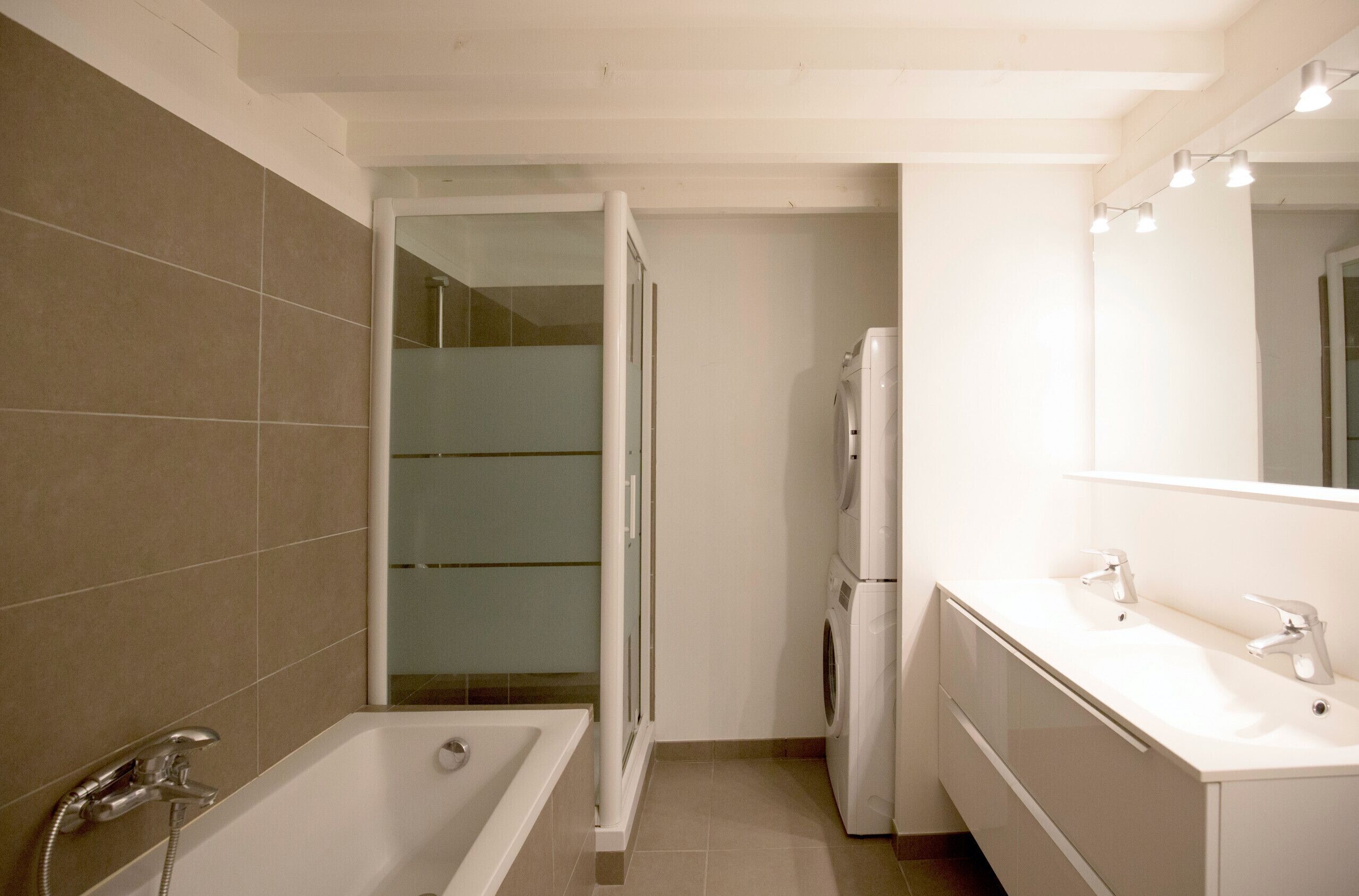 Bathtub, hair dryer, towels, toilet paper