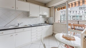 A modern kitchen with white cabinets, a black countertop, and a window overlooking a balcony with a view of buildings. - Spacious 2 bedrooms, Terrace, Parking, lift (Burdeos)