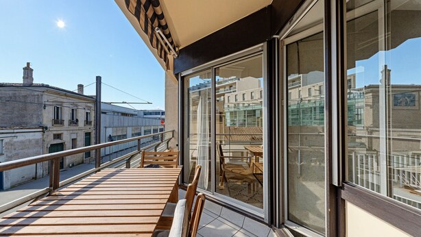 A balcony with a wooden deck, glass doors, and a view of the cityscape. - Spacious 2 bedrooms, Terrace, Parking, lift (Burdeos)