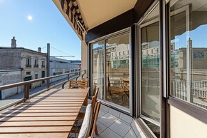 A balcony with a wooden deck, glass doors, and a view of the cityscape. - Spacious 2 bedrooms, Terrace, Parking, lift (Burdeos)