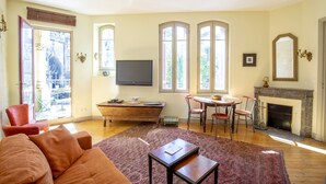 A living room with a sofa, a coffee table, a fireplace, and a television. - Historic center, air-conditioned with terrace (Burdeos)