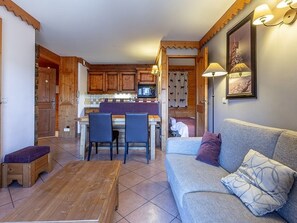 Un salon confortable avec un canapé, une table basse et un coin repas comprenant des chaises et une table.
