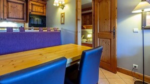Una cucina accogliente con mobili in legno, un tavolo da pranzo con sedie blu e una panca a incasso.