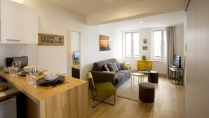 Een modern appartement met keuken, eethoek, woonkamer en een klein kantoor.