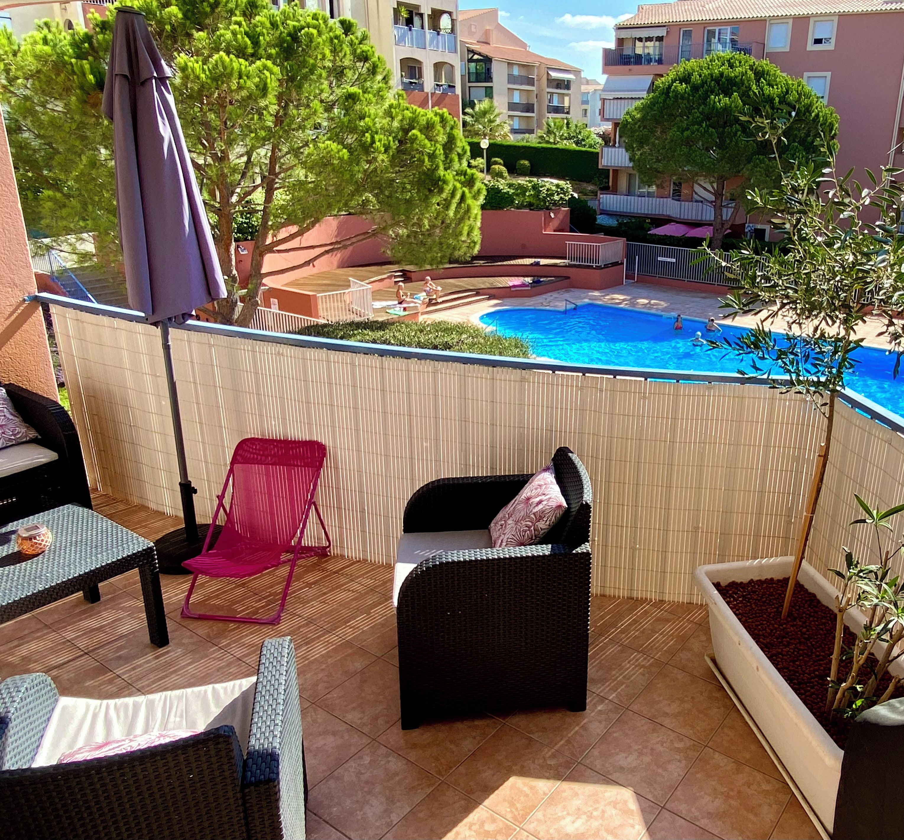 Eine Dachterrasse mit Gartenmöbeln, einem Swimmingpool und Blick auf die umliegenden Gebäude.