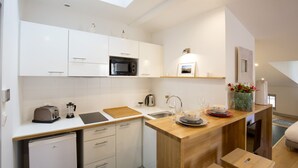 A modern kitchen with white cabinets, a microwave, a toaster, and a wooden countertop. - Bordeaux Historic Center Superior double studio (Burdeos)