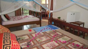 Ein Schlafzimmer mit Himmelbett, Schreibtisch und Stuhl.