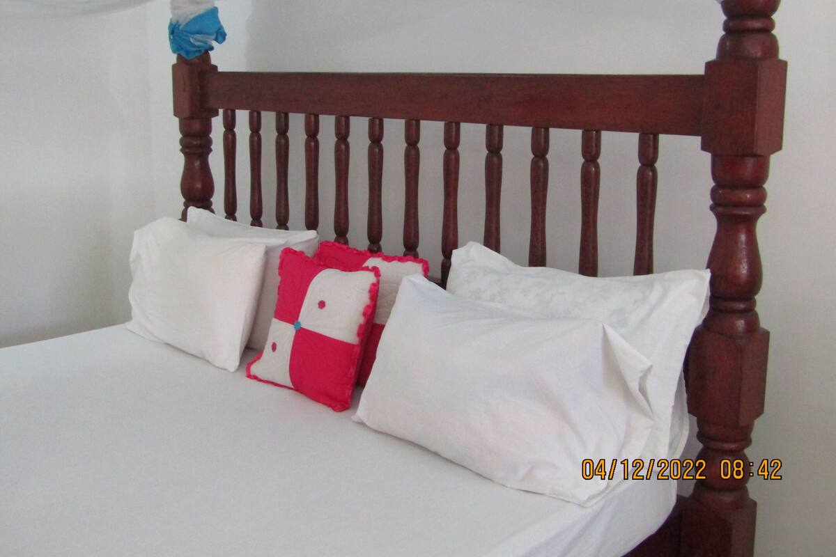 A bed with a wooden headboard and white bedding.