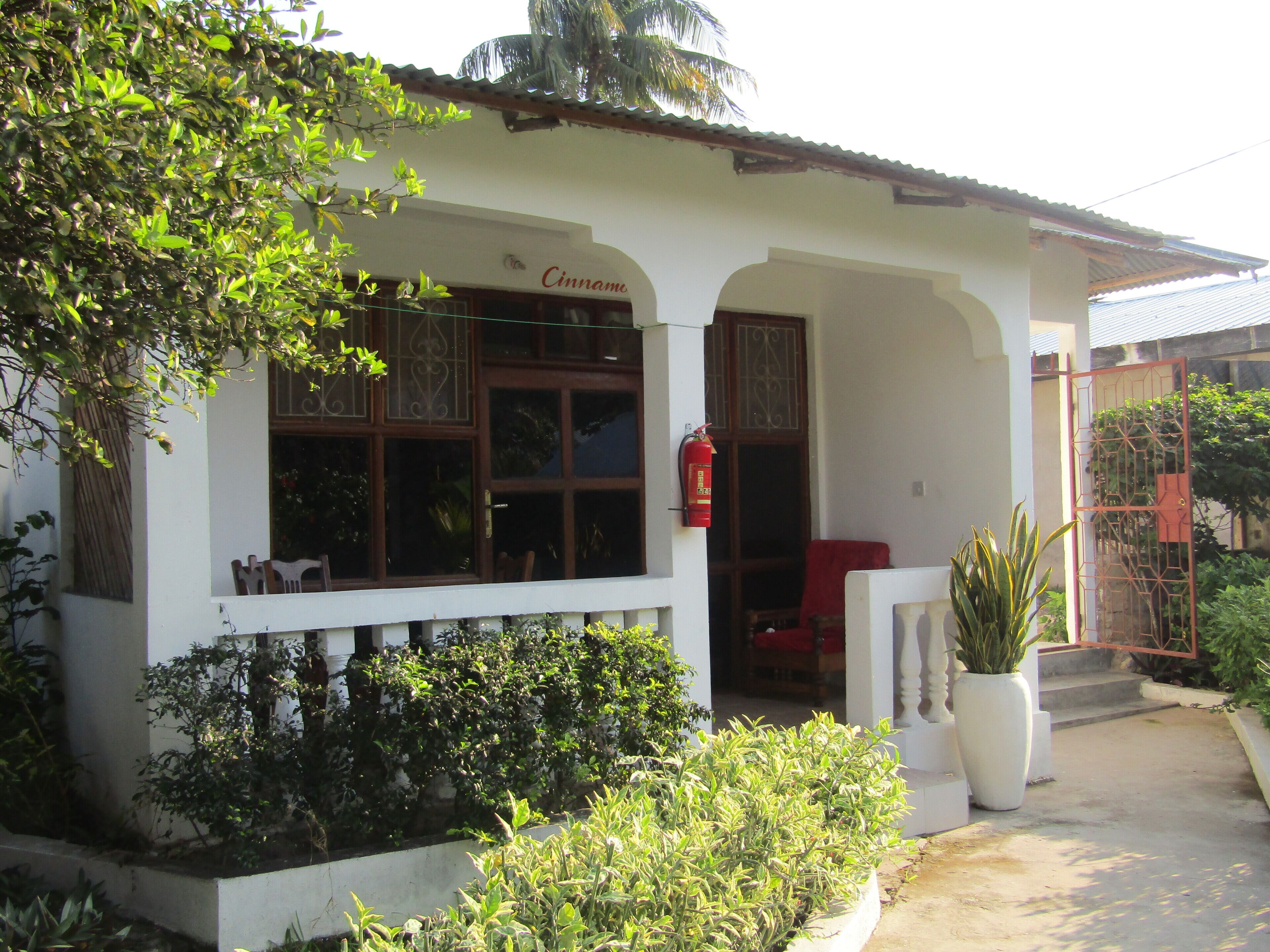 A white building with a sign reading "Cinnamo".
