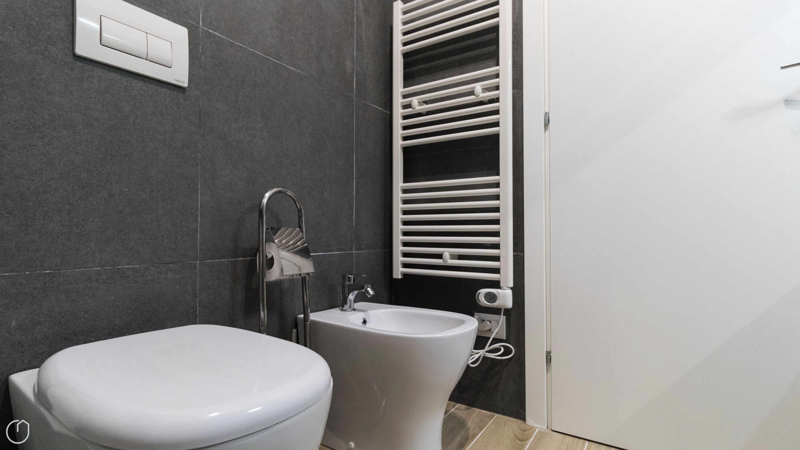Ein Badezimmer mit Toilette, Waschbecken und Handtuchhalter.