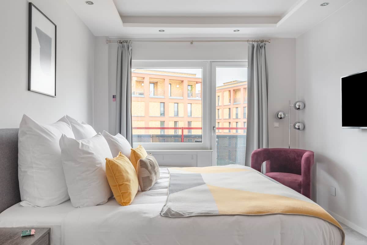 Une chambre d’hôtel moderne équipée d’un grand lit, d’un bureau, d’une chaise et d’une télévision.