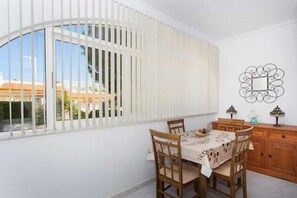 A dining area with a table set for four, a wooden cabinet, and a decorative mirror on the wall. - CH La Pinada Pueblo Bravo (Ciudad Quesada) (Ciudad Quesada)