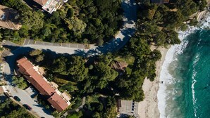 Vue aérienne d’une zone côtière avec une route, des bâtiments et une plage.