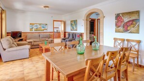 A spacious living area with a wooden dining table, multiple seating options, and artwork on the walls. - Villa Luis Vives with Mountain View, Wi-Fi, Garden, Balcony, Terraces & Pool (Port de Pollença)