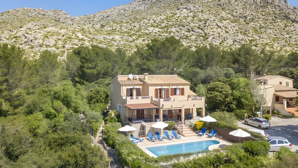 A two-story house with a swimming pool, surrounded by trees and a mountain. - Villa Luis Vives with Mountain View, Wi-Fi, Garden, Balcony, Terraces & Pool (Port de Pollença)