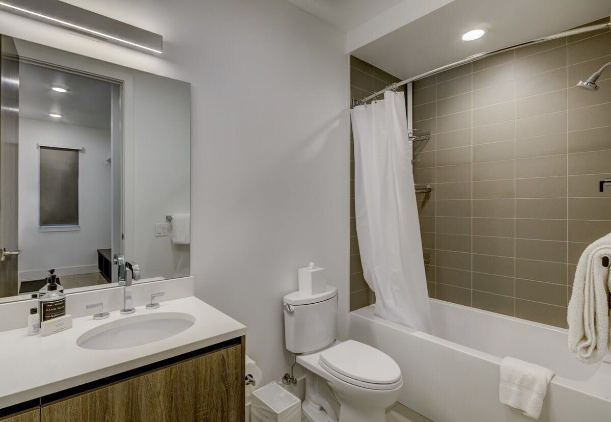 Ein modernes Badezimmer mit Waschbecken, Toilette und Badewanne.