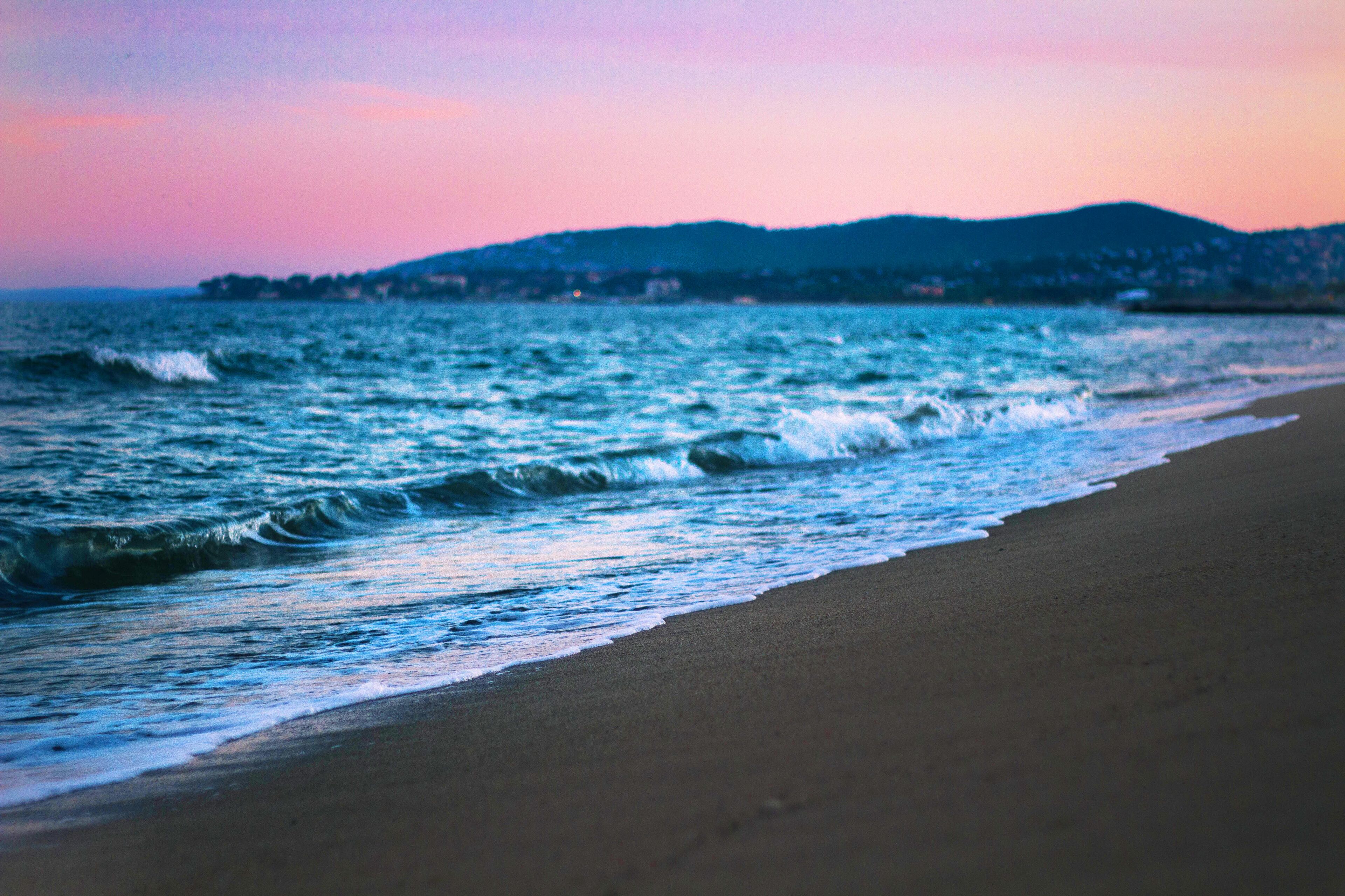 A beach with waves and a distant shoreline.