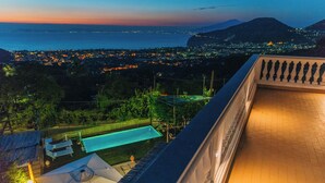 Una piscina en la azotea con vistas a un paisaje urbano al atardecer.