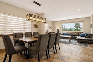 Un espace repas comprenant une table et des chaises, un canapé et une vue sur l’extérieur.