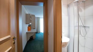 Een hotelbadkamer met een douche, toilet en wastafel.