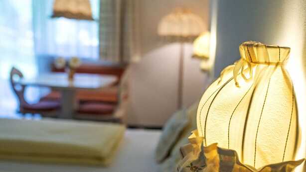 Une pièce comprenant un lit, une lampe et une table avec des chaises.