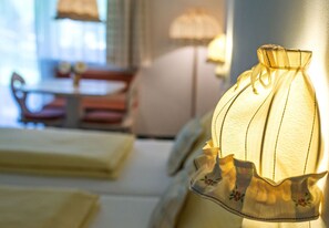 Ett rum med en säng, en lampa och ett bord med stolar.
