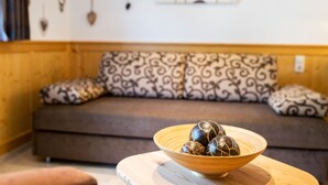 Ein Zimmer mit einer Couch und einem Holztisch mit einer Schale dekorativer Gegenstände.