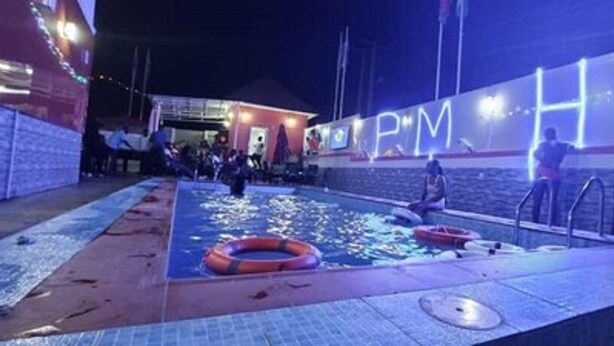 An outdoor swimming pool area with a lifebuoy and a small inflatable boat. - Peace Media Hotels Gwarimpa (Abuja)