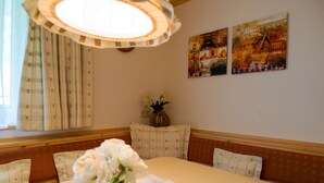 Ein Essbereich mit einem Tisch für vier Personen, einer Blumenvase und zwei Bildern an der Wand.