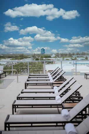 Una piscina al aire libre, camas de piscina gratis, sombrillas